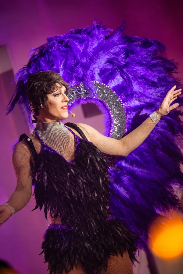 Miss Caline en costume à plumes violettes